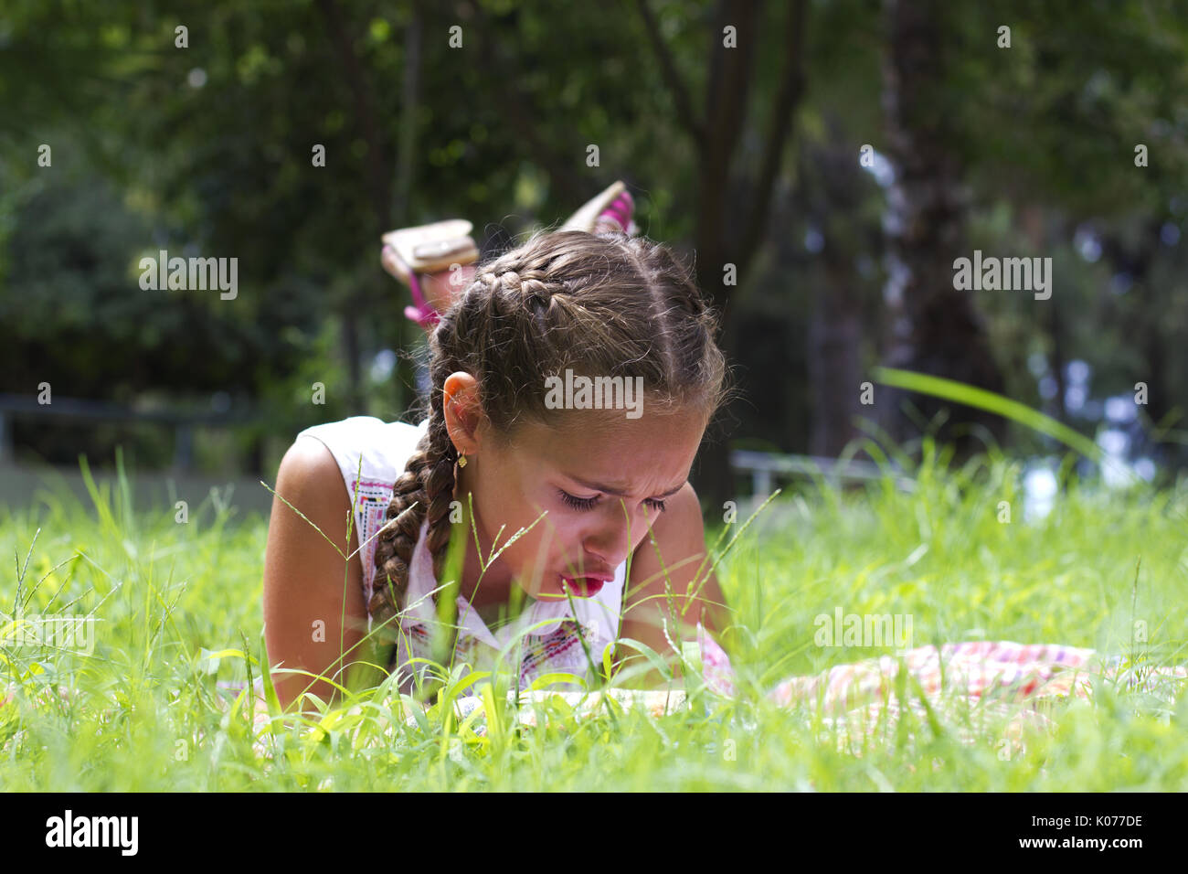 Junge jugendlich Mädchen liegt auf der grünen Wiese und Buch lesen Stockfoto