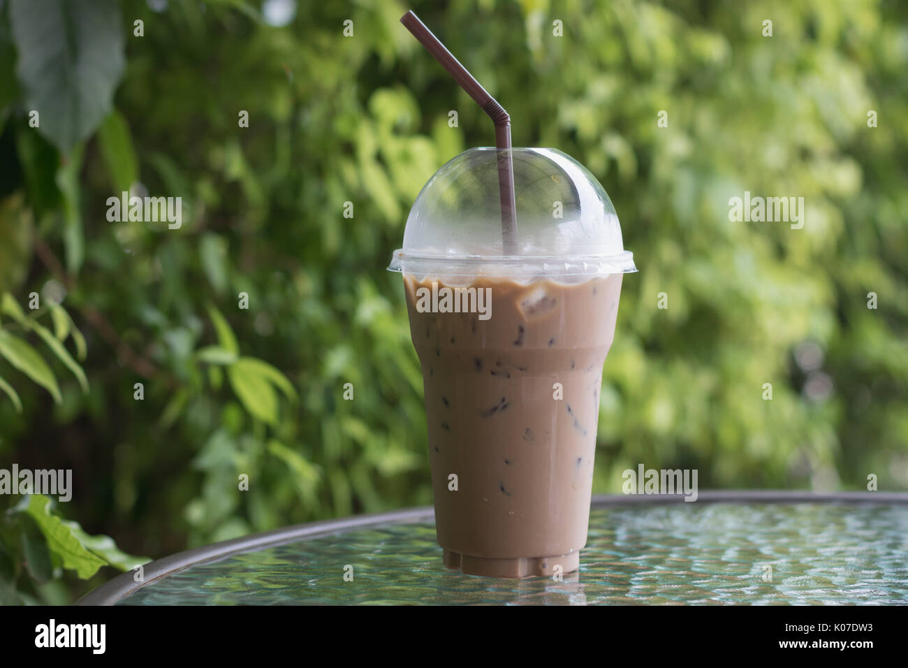 Eiskaffee im take away Becher (Glas) auf dem Tisch im Cafe Stockfotografie