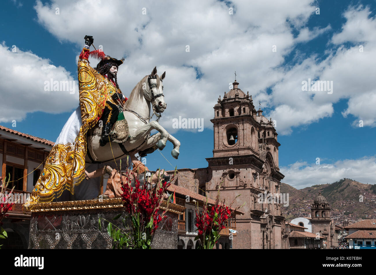Eine Statue des Heiligen Jakobus mit Kirche La Compania de Jesus im Hintergrund, während Sie im Corpus Christi feiern an der Plaza de Armas, Cusco, Peru. Stockfoto