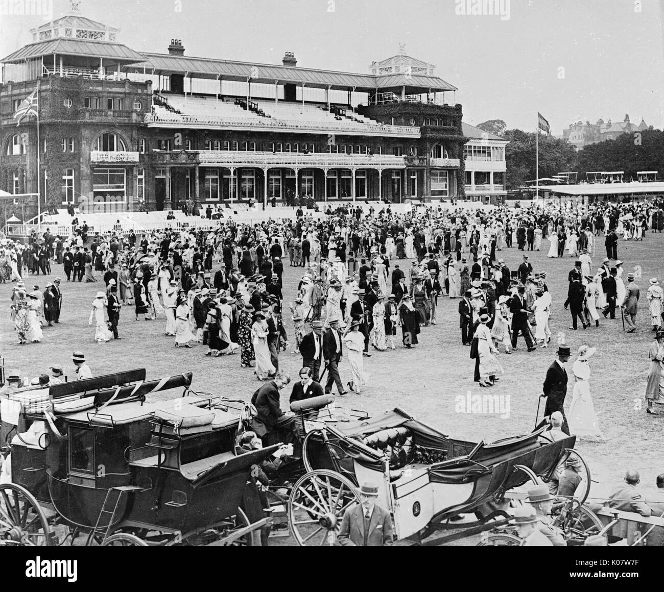 Szene während der jährlichen Eton v Harrow Cricket-spiel an den Lords Cricket Ground in NW-London, 13. Juli 1934. Menschen flanieren über während der Mittagspause, mit traditionellen Kutschen im Vordergrund. Das Spiel selbst war ein Unentschieden. Datum: 1934 Stockfoto