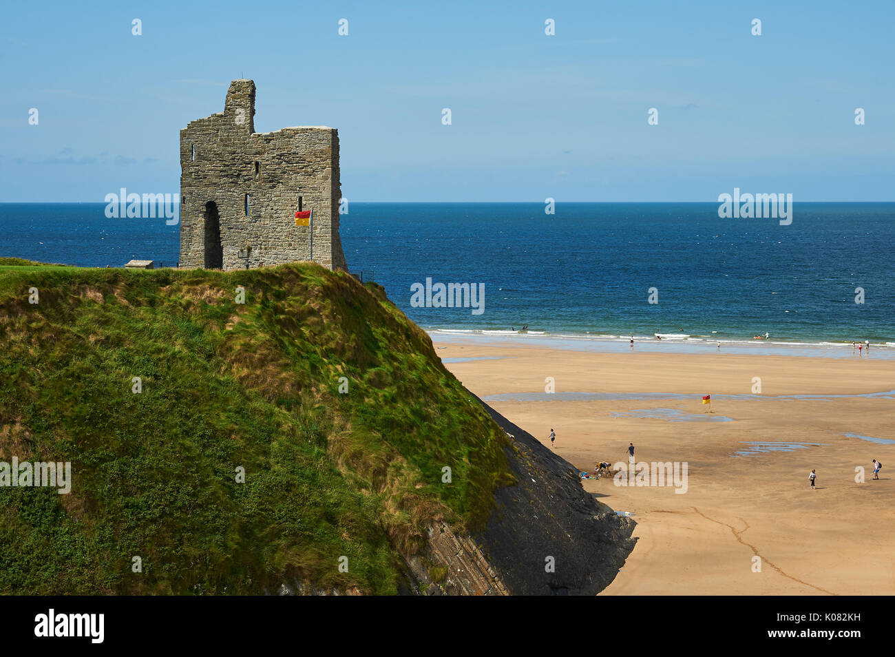Die Ruinen von ballbunion Castle im County Kerry über den breiten Sandstrand und den Atlantik auf einem ruhigen Sommer Tag schauen. Stockfoto