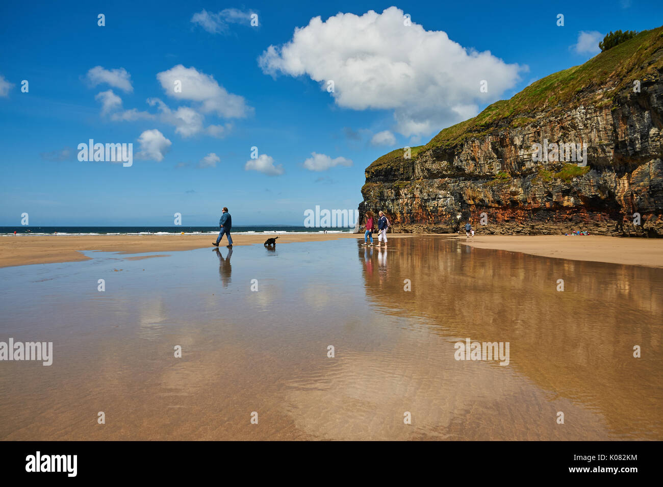 Ebbe auf Ballybunion Strand, County Kerry mit dem Himmel und den Menschen in einen Pool von Wasser an einem Sommertag wider. Stockfoto