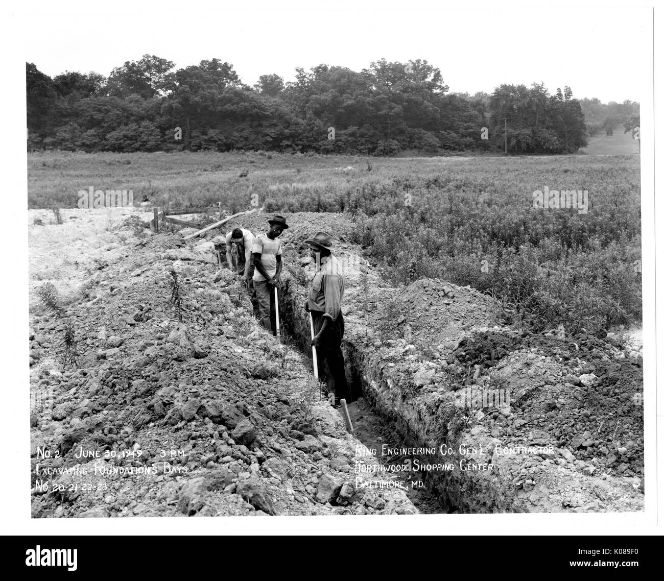 Foto der Arbeitnehmer für Ring Ingenieurbüro Generalunternehmung arbeiten auf dem unbebauten Gelände der Northwood Shopping Center in Baltimore, Maryland, mit Feldern und Bäumen im Hintergrund, Baltimore, Maryland, 30. Juni 1949. Stockfoto