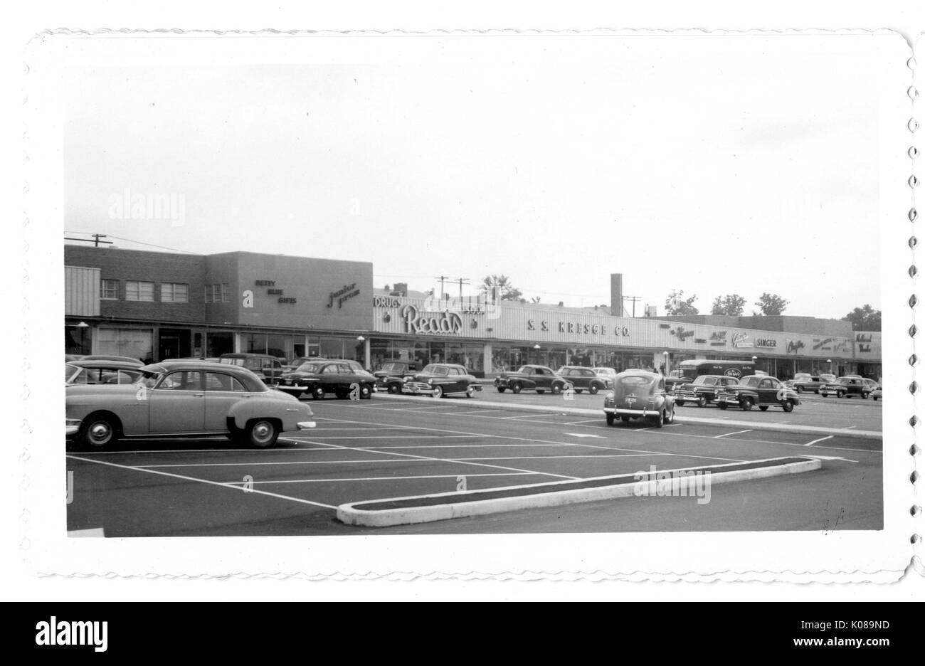 Foto der Parkplatz für die Northwood Shopping Center in Baltimore, Maryland, mit Autos und kommerziellen Gebäuden wie Liest, S S Kresge Firma, und Sänger, Baltimore, Maryland, 1951. Stockfoto