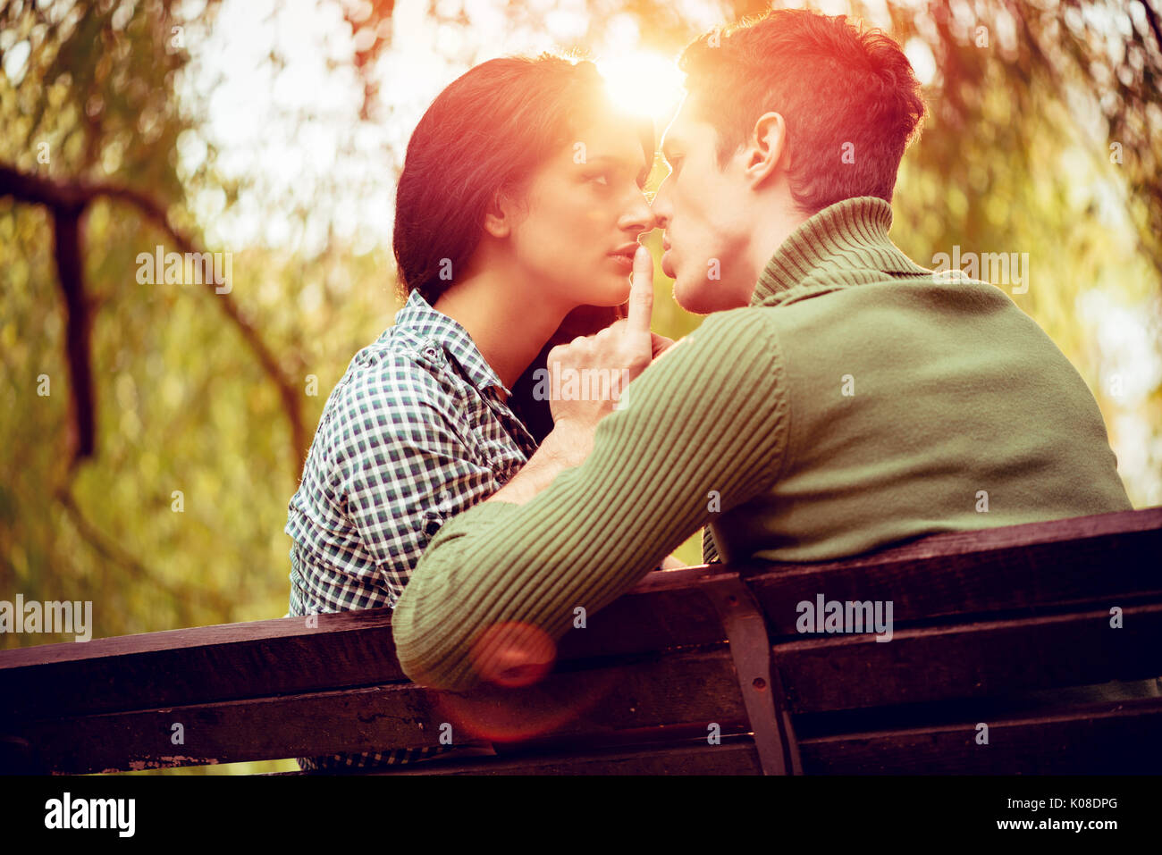 Schöne Paar schöne auf der Bank sitzen und genießen im sonnigen Park in herbstlichen Farben. Stockfoto