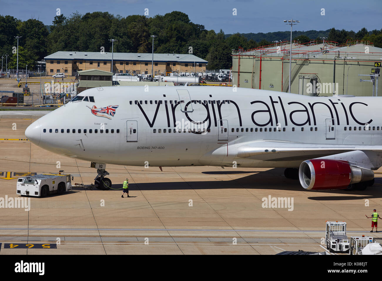 Pushback Traktoren und Schlepper bewegt sich Virgin Atlantics Lackierung 474 400 Tinker Belle am Nordterminal des Flughafen Gatwick Stockfoto