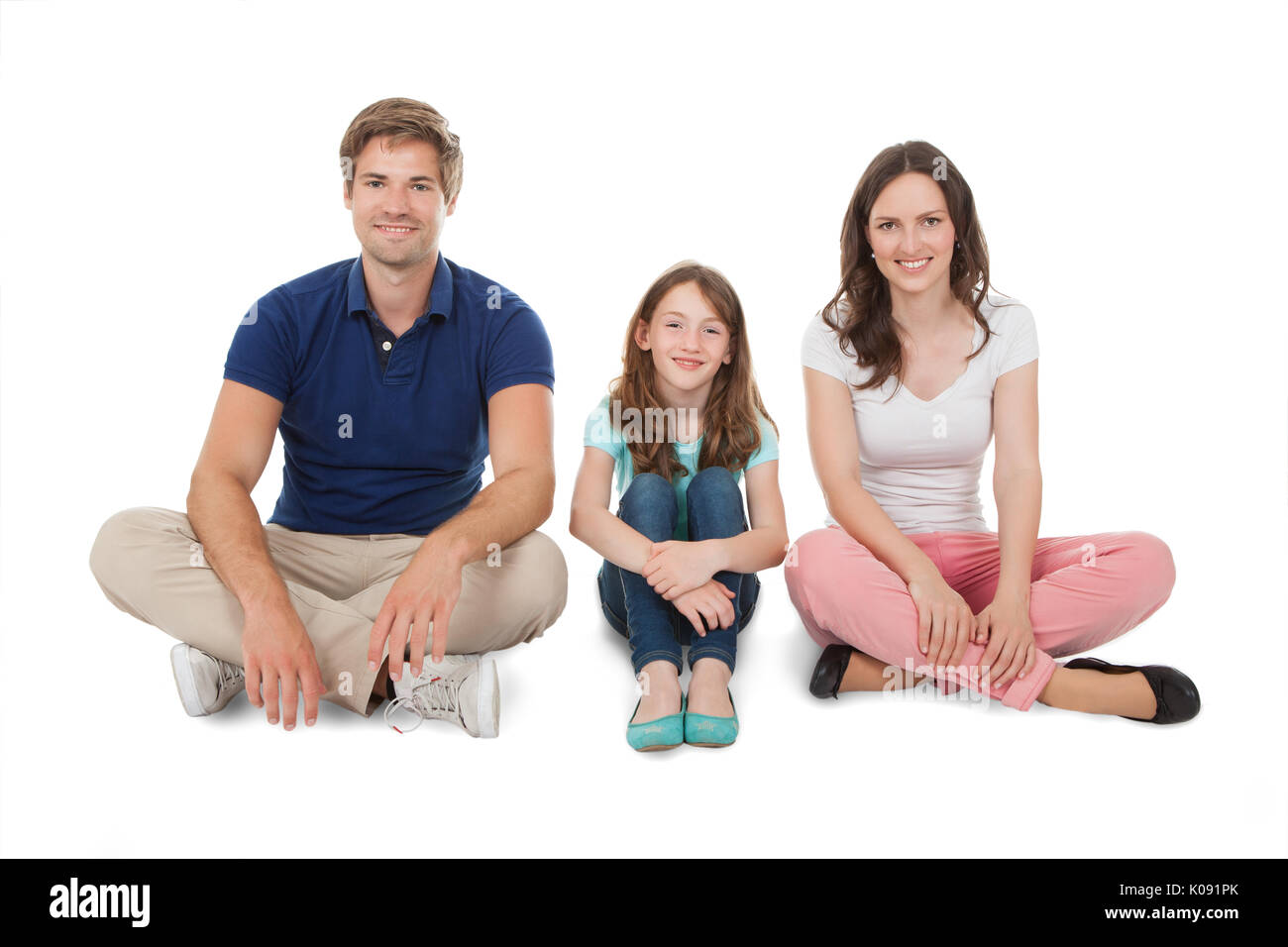 Volle Länge Portrait von Happy Family auf weißem Hintergrund sitzen Stockfoto