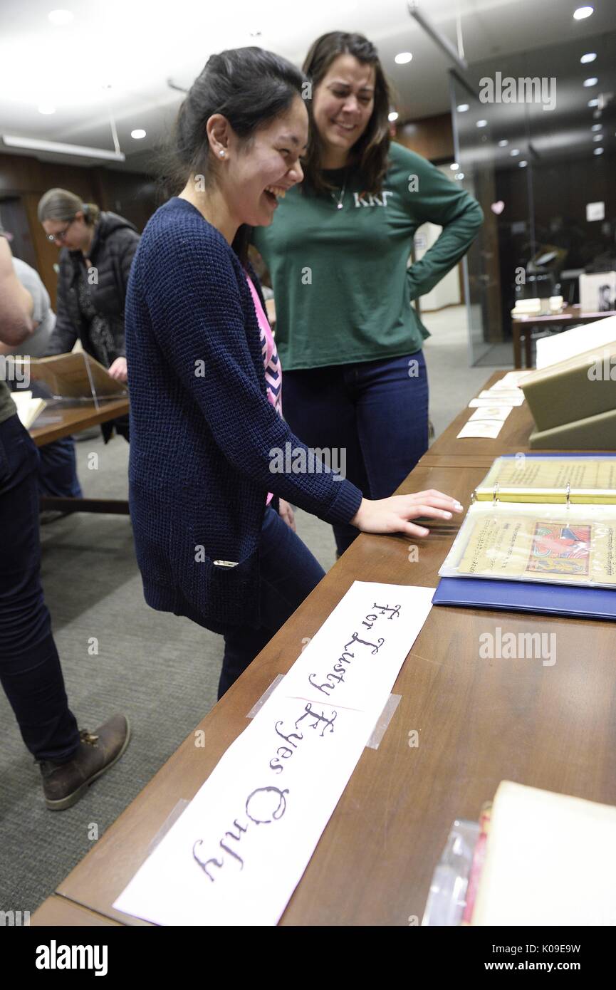 Zwei weibliche Studenten an einer Probe lachend auf einem Tisch, der über das Zeichen, "Nur der lüsternen Augen', 11. Februar 2016. Stockfoto