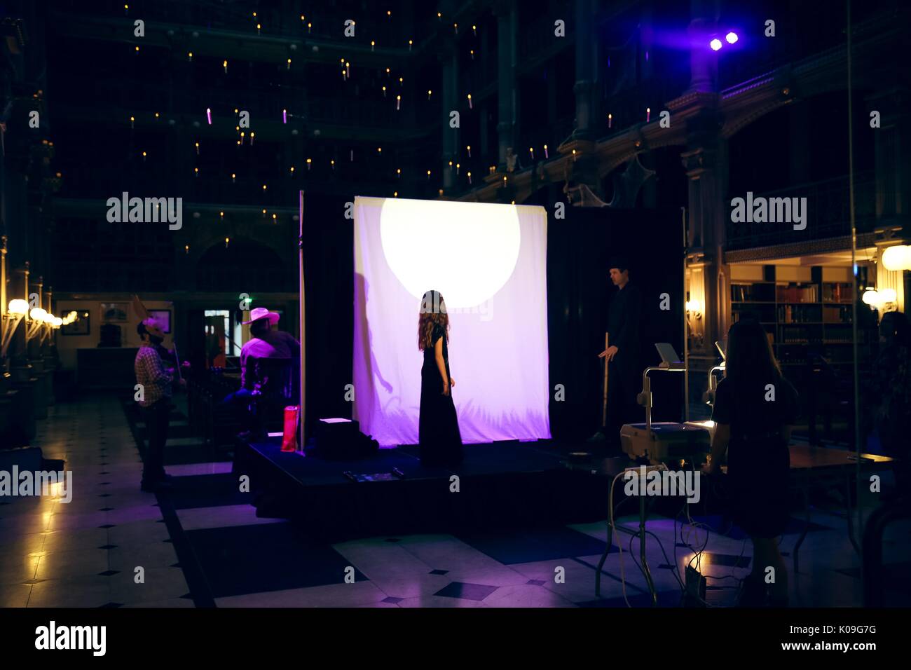 Ein Mädchen in einem langen dunklen Kleid und ein Mann in einem Hut mit einem Stock auf der Bühne, sondern hinter einem Vorhang, ihre Schatten auf den Vorhang für das Publikum zu sehen, projiziert, während ein Schatten Puppenspiel, 2015. Mit freundlicher Genehmigung von Eric Chen. Stockfoto