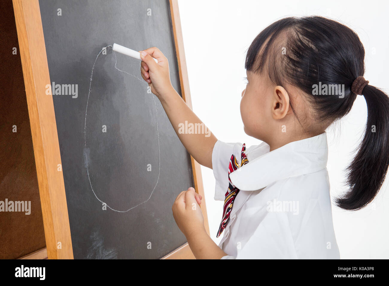Asiatische chinesische Mädchen Zeichnung auf blackboard in isolierten weißen Hintergrund Stockfoto