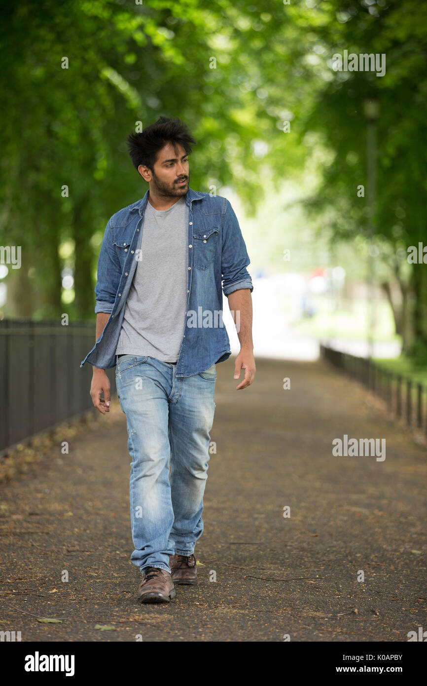 Porträt einer trendigen indischen Mann zu Fuß in einer City Park. Stockfoto