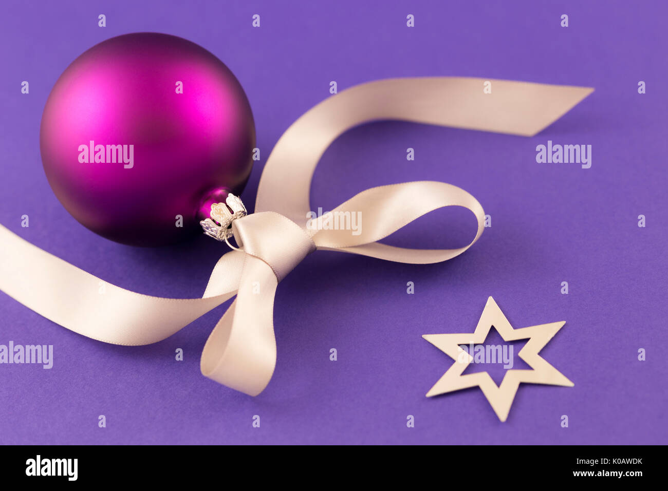 Schönen lila christmas ball mit satin Wirkung, grau Geschenkband und metallic silber Sterne auf lila Hintergrund. Stockfoto