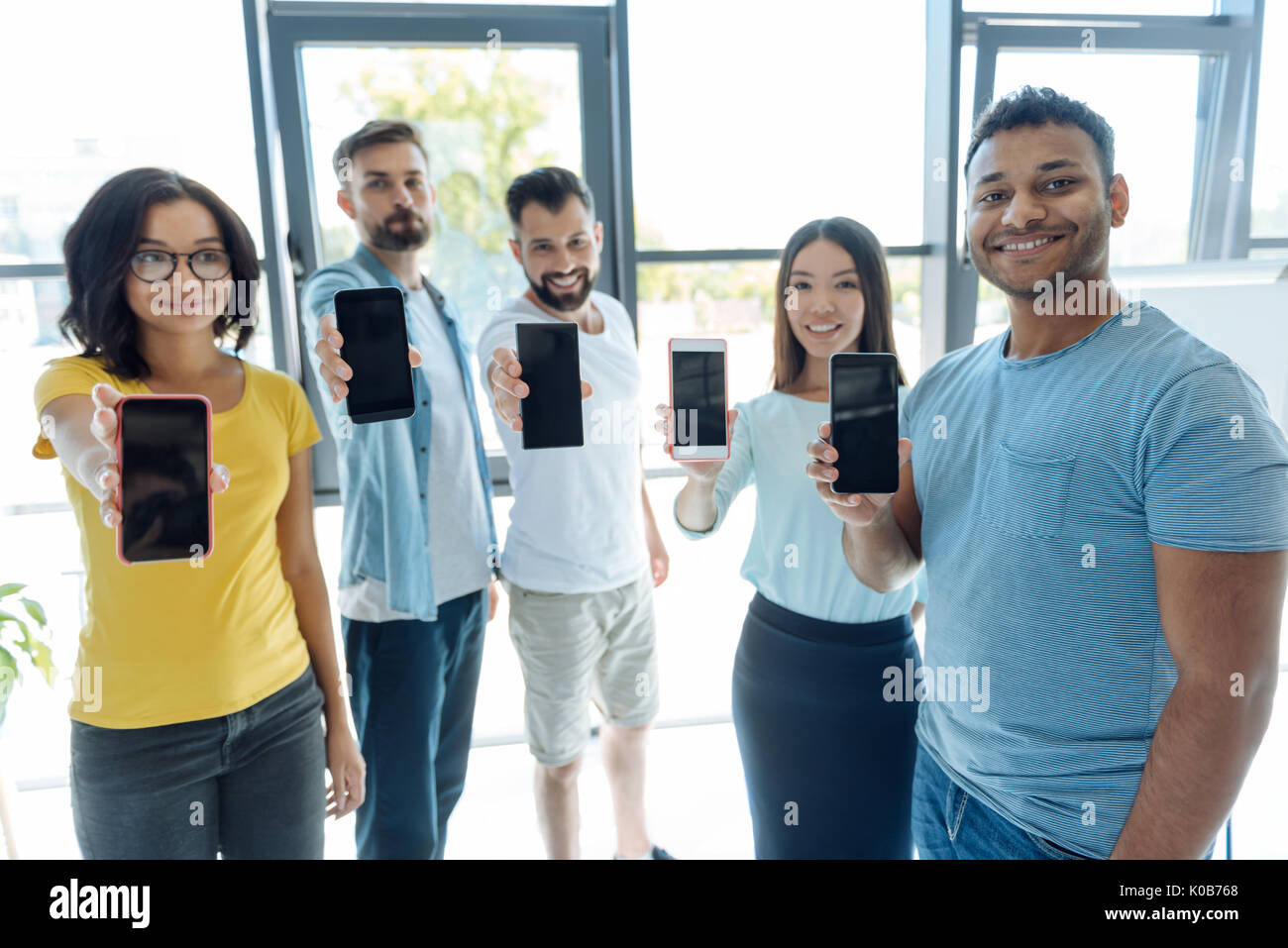 Nette junge Leute zeigen sie ihre Smartphones Stockfoto
