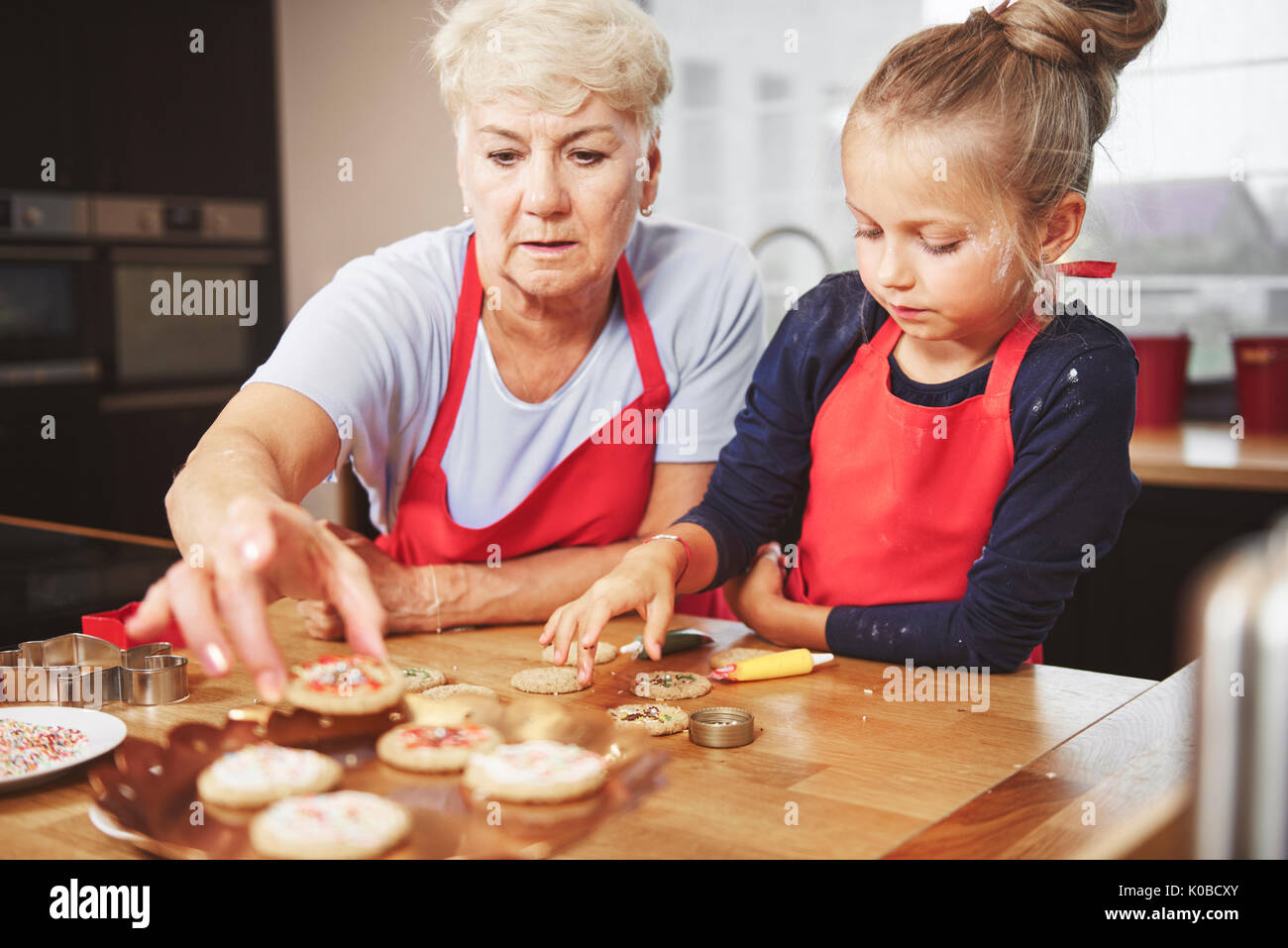 Oma und Enkelin Dekorieren Cookies Stockfoto
