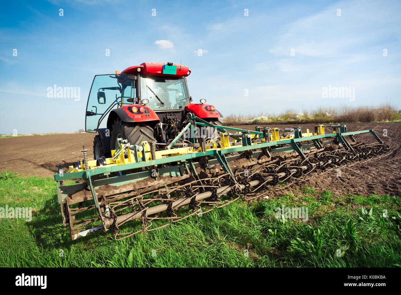 Bauer im Traktor Vorbereitung land mit saatbeet Kultivator im frühen Frühjahr Stockfoto