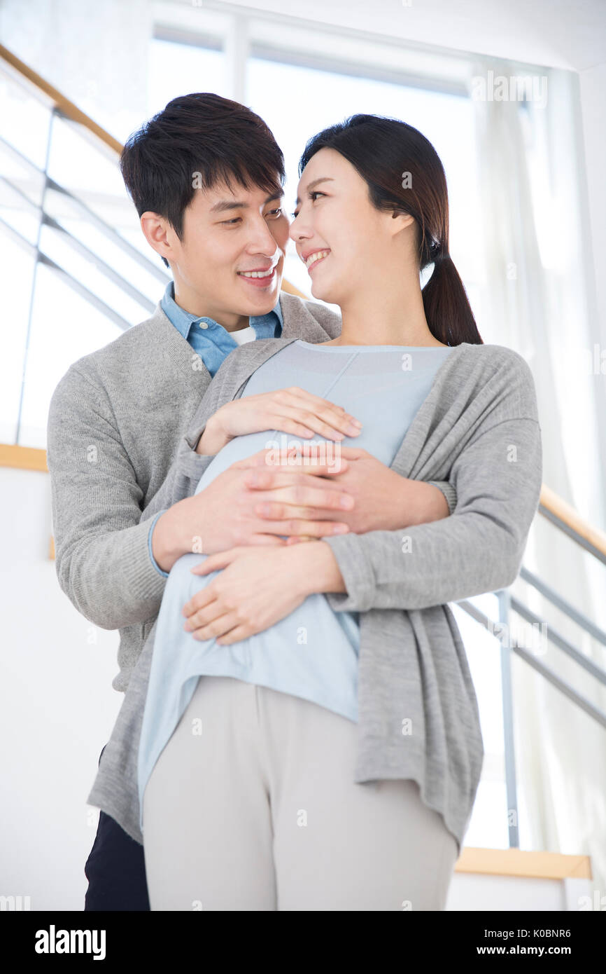 Liebevoller Ehemann seine schwangere Frau umarmen Stockfoto