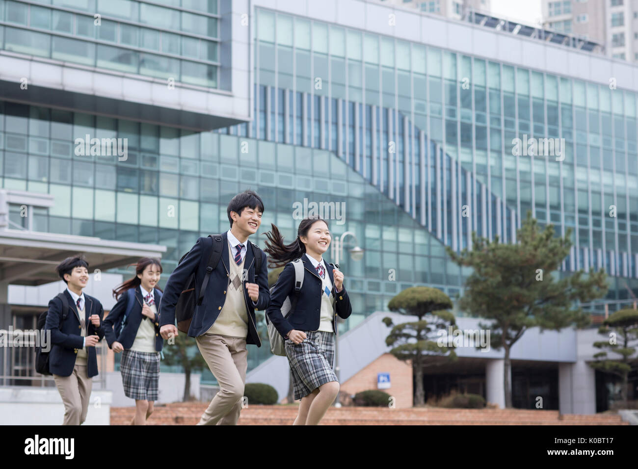 Lächelnd Schüler gegen ihre Schule läuft Stockfoto