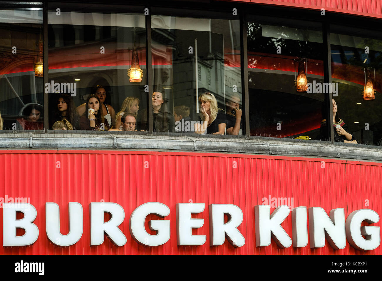 Die Menschen warten im Obergeschoss in den Burger King mit Blick auf den Leicester Square in der Hoffnung zu sehen, die Sterne am LOGAN LUCKY UK Premiere am Montag, 21. August 2017 VUE West End, den Leicester Square, London statt. Stockfoto