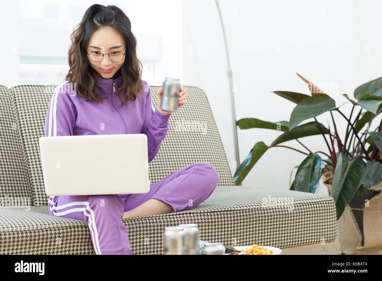 Junge lächelnde NEET Frau mit Notebook Computer trinken Stockfoto