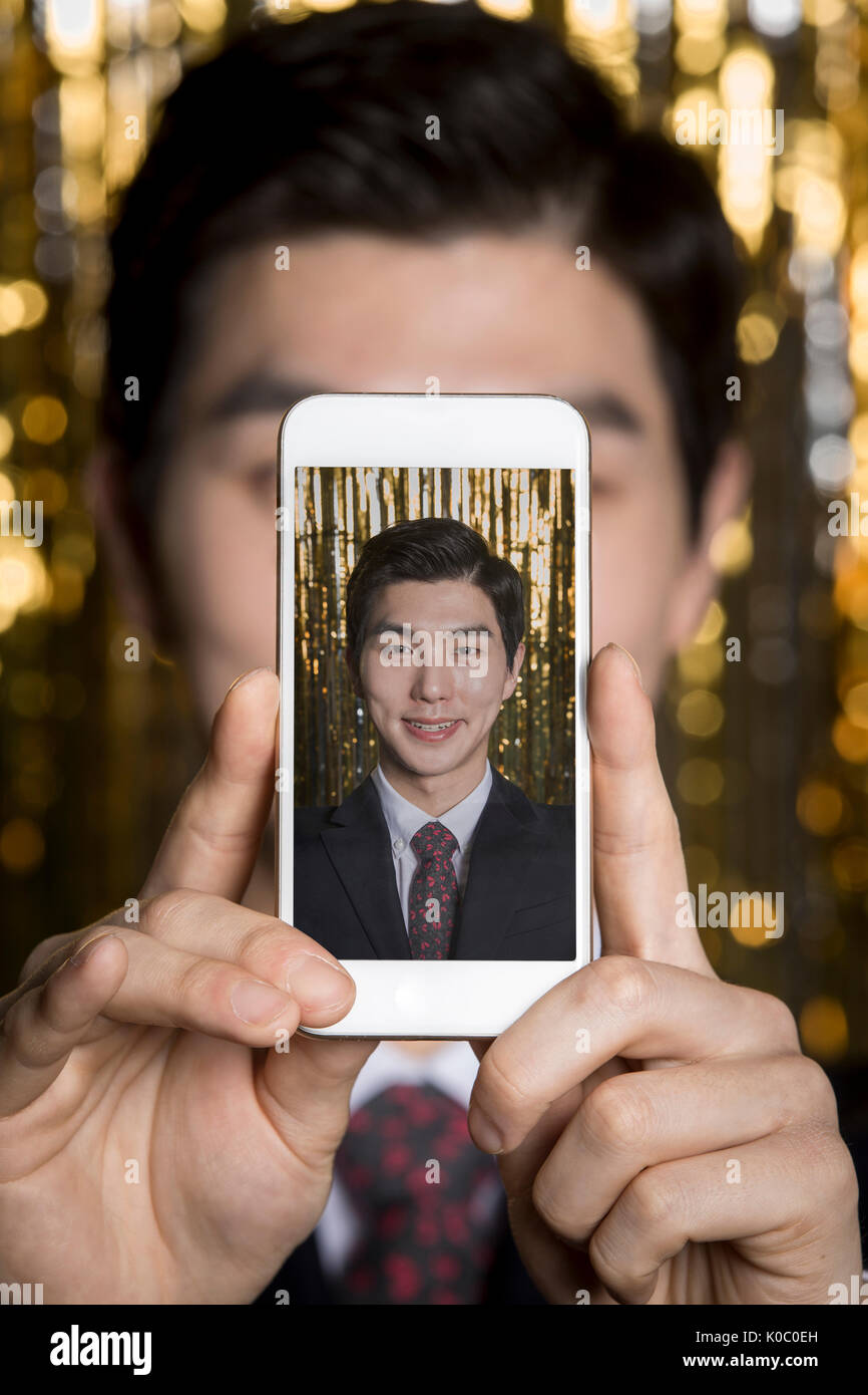 Portrait der junge lächelnde Mann einen selfie bei Party Stockfoto