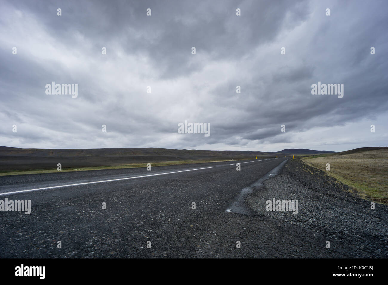 Island - Dunkle Straße ohne Ende durch die Lavafelder Stockfoto