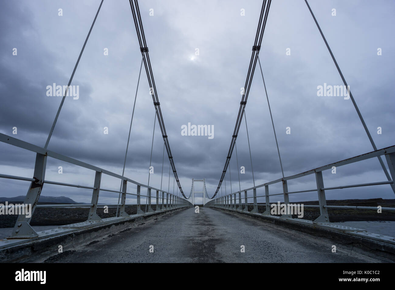 Island - Seilbrücke über den Fluss mit düsterer Atmosphäre Stockfoto