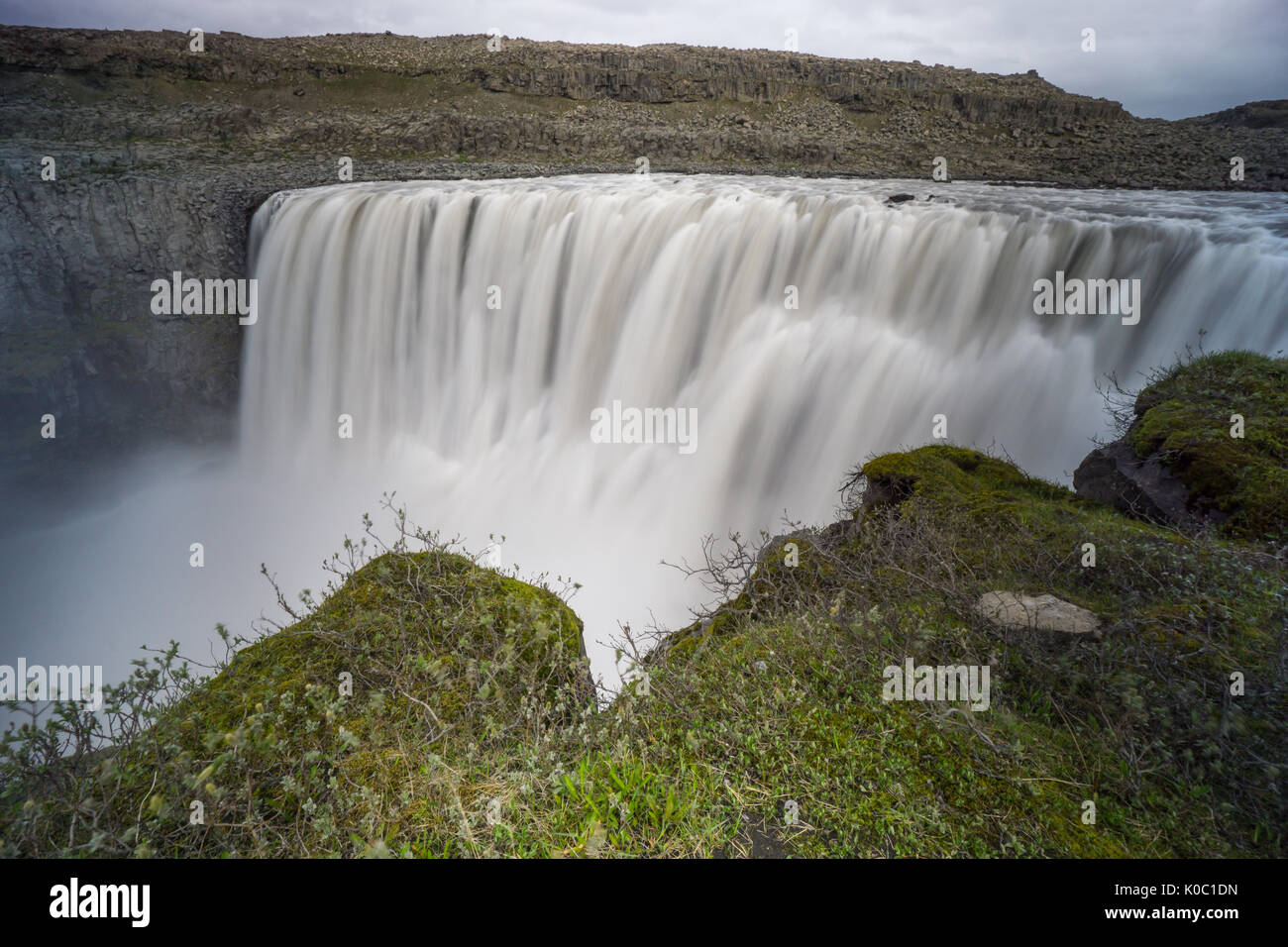 Island - Beeindruckende detifoss Wasserfall zeit Exposition, bei grünen Klippe Stockfoto