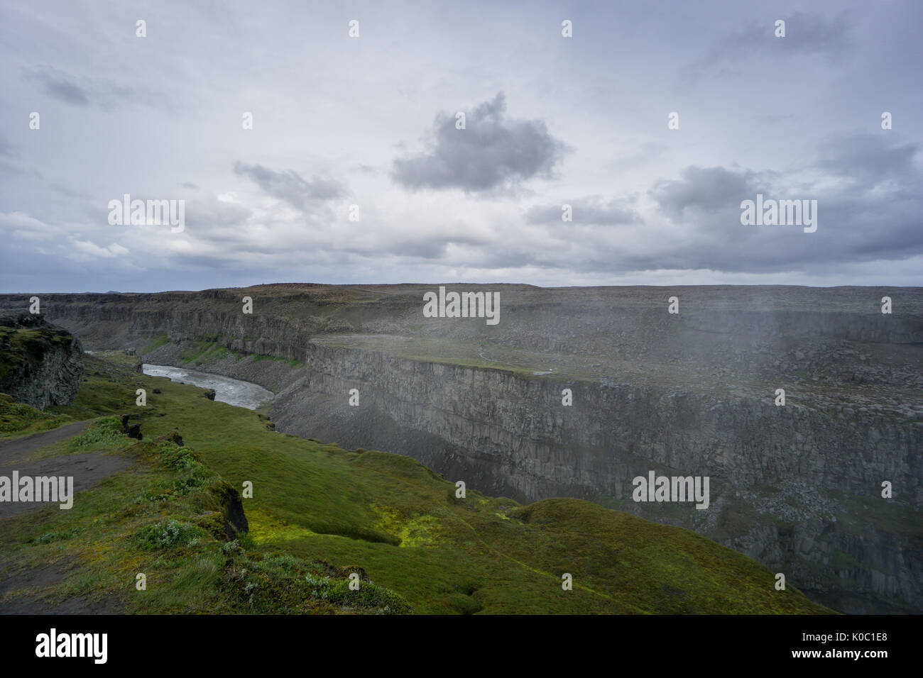 Island - riesige Schlucht von detifoss Wasserfall mit Fluss unter grünen Moos bedeckte Fläche Stockfoto