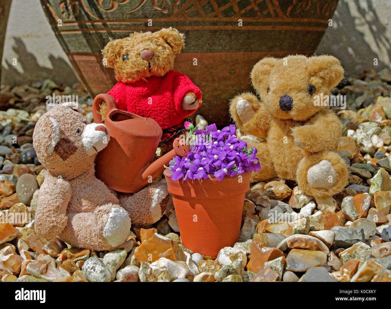 Tableau von Miniatur Teddybären in Garten im Sommer Sonnenschein mit Miniatur Ton Gießkanne und Flower Pot. Stockfoto