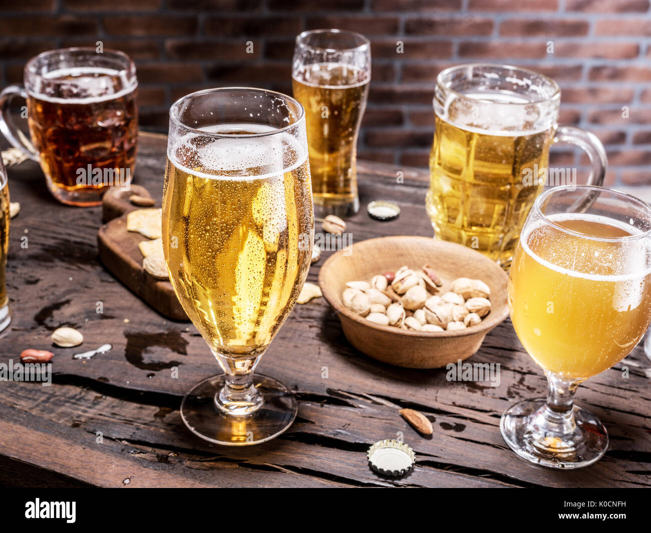Gläser Bier und Snacks auf dem Holztisch. Stockfoto