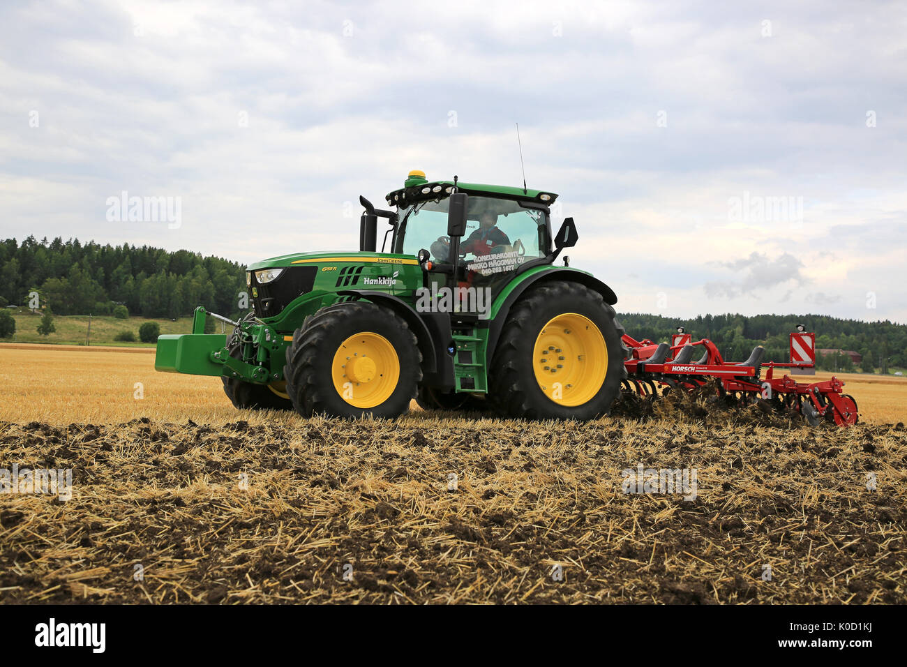 SALO, Finnland - 18. AUGUST 2017: Landwirt arbeitet mit John Deere 6155R Traktor und Grubber Horsch Terrano 3 FX auf Puontin Peltopaivat 2017 Landwirtschaftliche Stockfoto