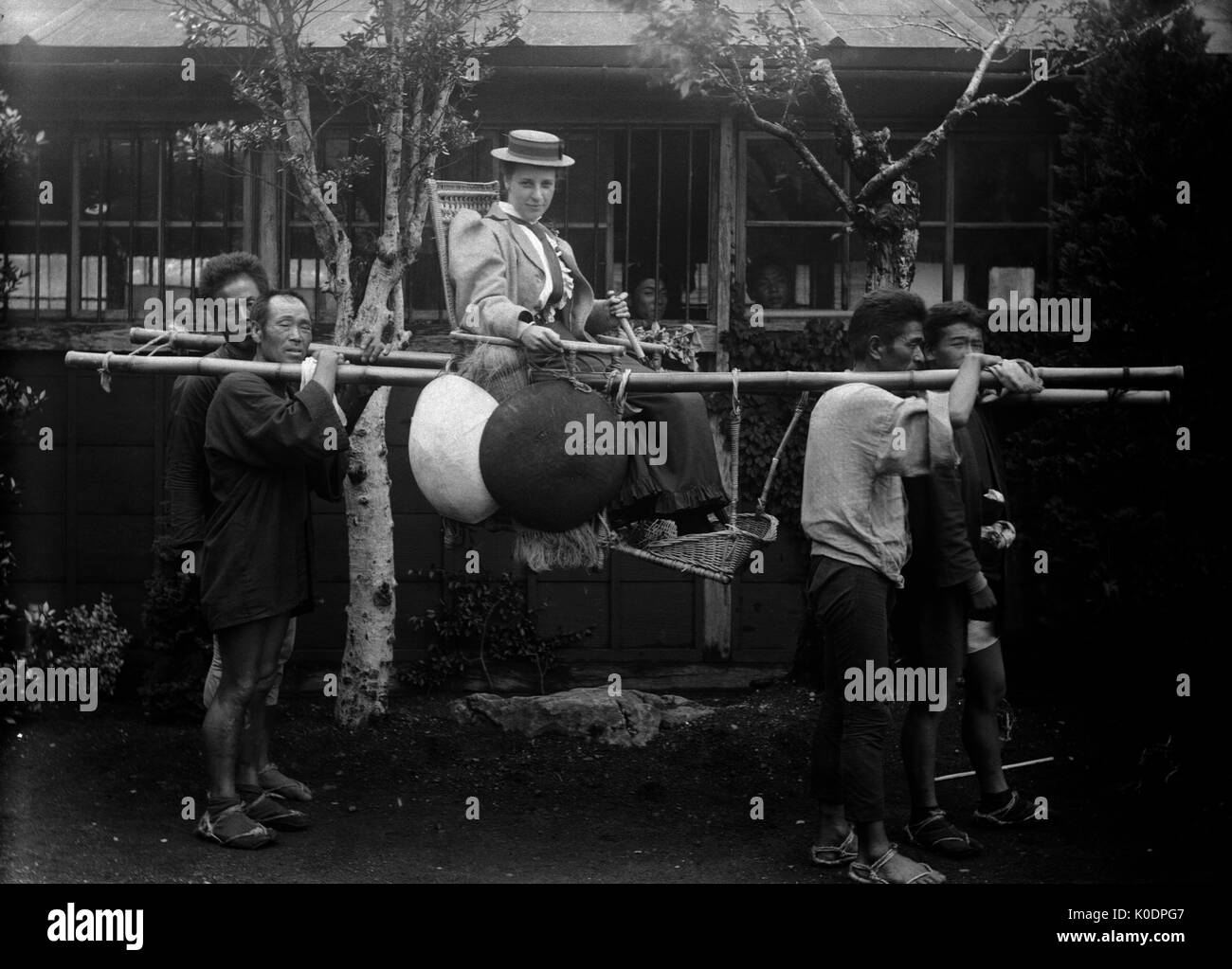 AJAXNETPHOTO. 1900-1910 (ca.). JAPAN. - Personal - eine Dame in einem Stuhl Wurf mit SCHAULUSTIGEN IM HINTERGRUND transportiert. Fotograf: unbekannt © DIGITAL IMAGE COPYRIGHT AJAX VINTAGE BILDARCHIV QUELLE: AJAX VINTAGE BILDARCHIV SAMMLUNG REF: 171308 102 Stockfoto