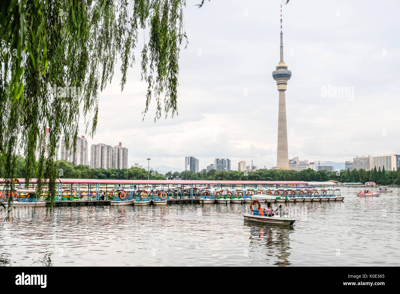 Leute fahrende Boot an Yu Yuan Tan Park mit CCTV-Turm im Hintergrund Stockfoto