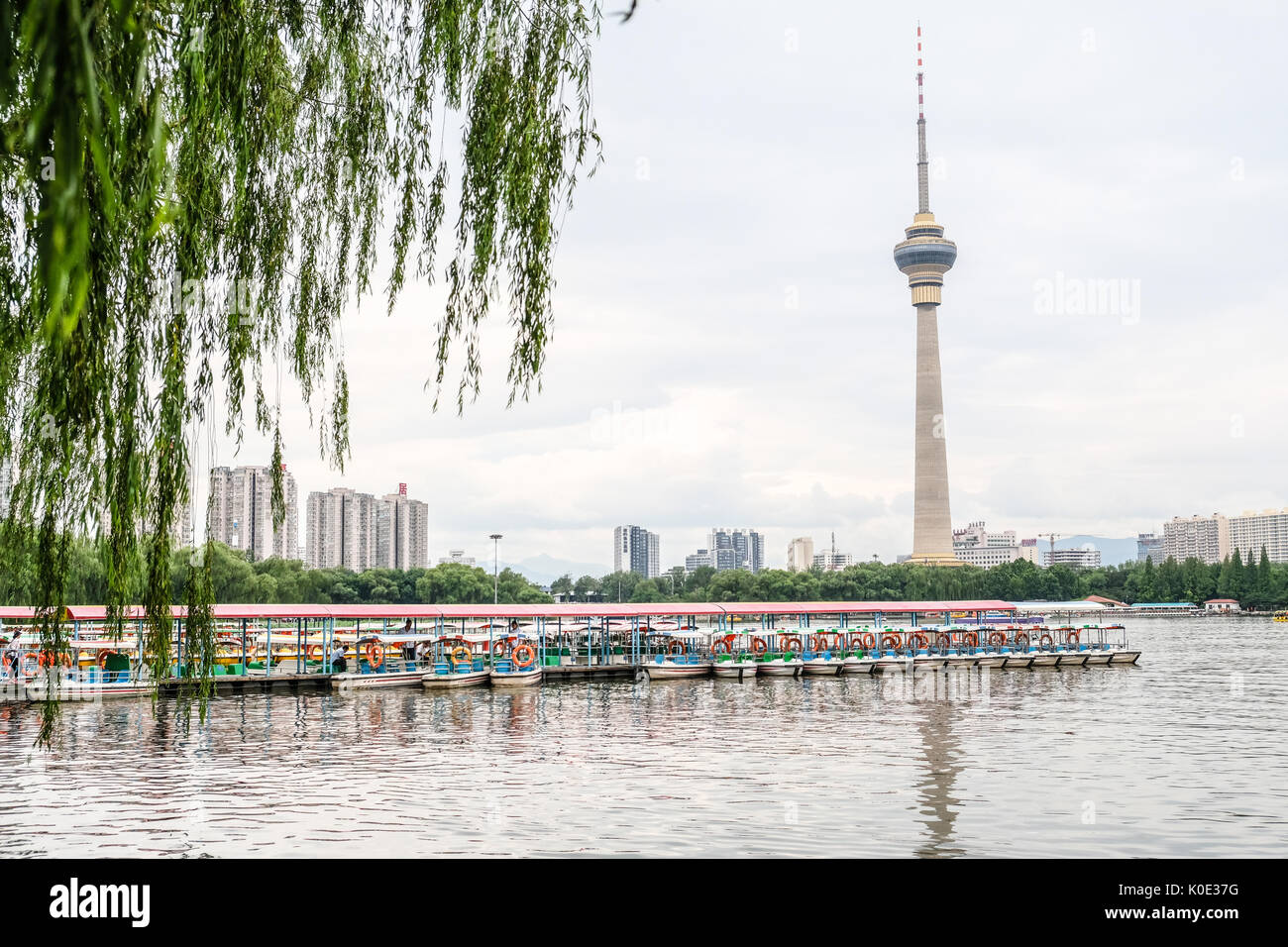 Leute fahrende Boot an Yu Yuan Tan Park mit CCTV-Turm im Hintergrund Stockfoto