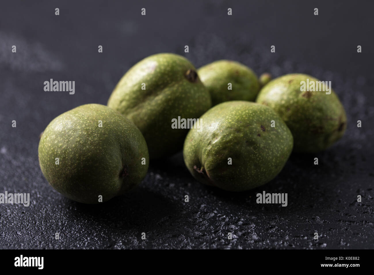 Frische grüne Walnüsse in die Haut direkt vom Baum. Walnüsse auf schwarzem Hintergrund. Makro. Frische Ernte. Stockfoto