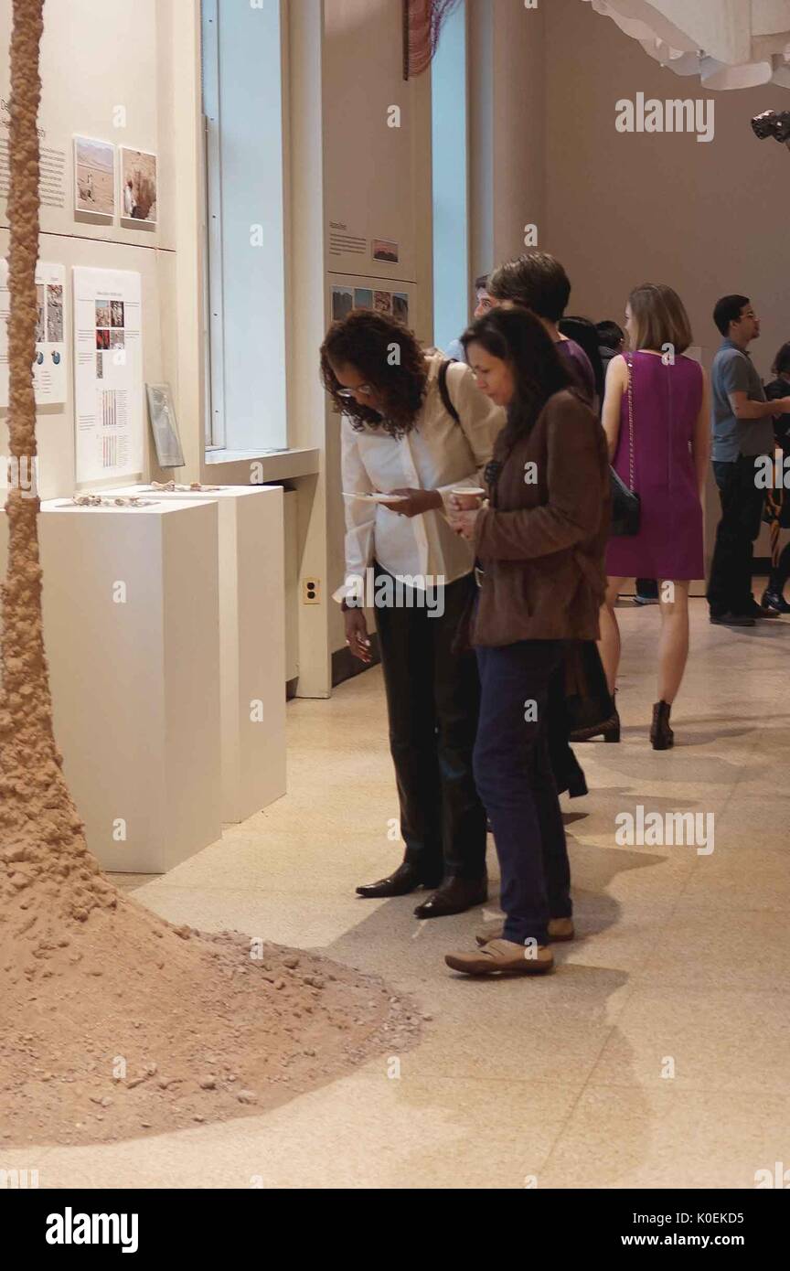 Studenten und Mitglieder der Johns Hopkins und Glimmer Gemeinschaften Blick auf Objekte auf dem Display für die Öffnung von Back to Earth: Vorbereitung einer Reise zum Mars, eine Ausstellung und Zusammenarbeit zwischen dem Maryland Institut Hochschule der Kunst (Glimmer) und der Johns Hopkins University, die in der Gallery Q in der Milton S. Eisenhower Bibliothek übernahm die Homewood Campus der Johns Hopkins University in Baltimore, Maryland. Mai, 2014. Mit freundlicher Genehmigung von Eric Chen. Stockfoto