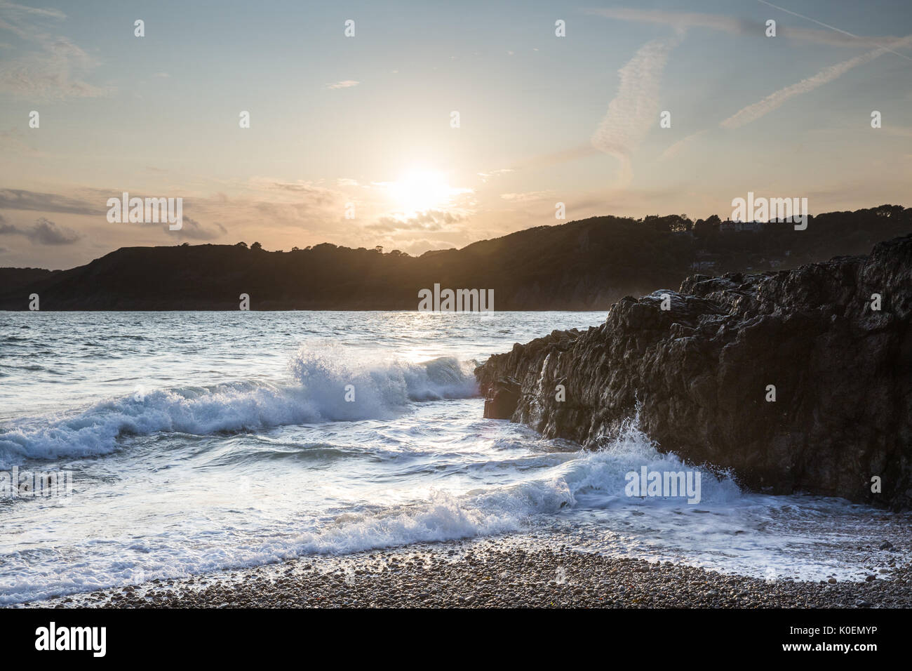 Eine Küstenstadt Sonnenuntergang Szene mit Meer, Sonne Sand und Felsen in der Nähe von Caswell Bay auf der Halbinsel Gower in Wales, Großbritannien Stockfoto