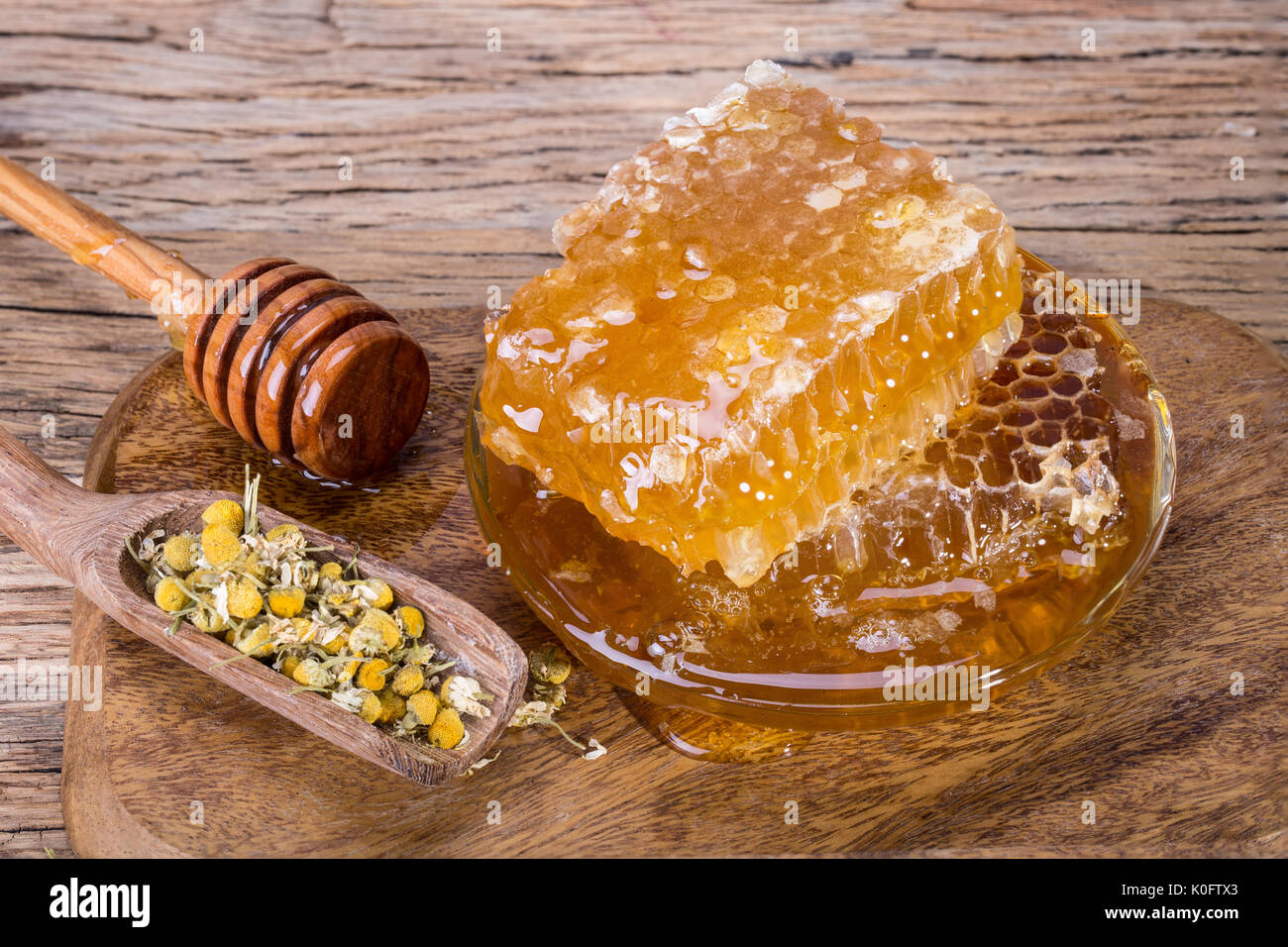 Waben und Honig Löffel auf einem Holzbrett und Tabelle Stockfoto