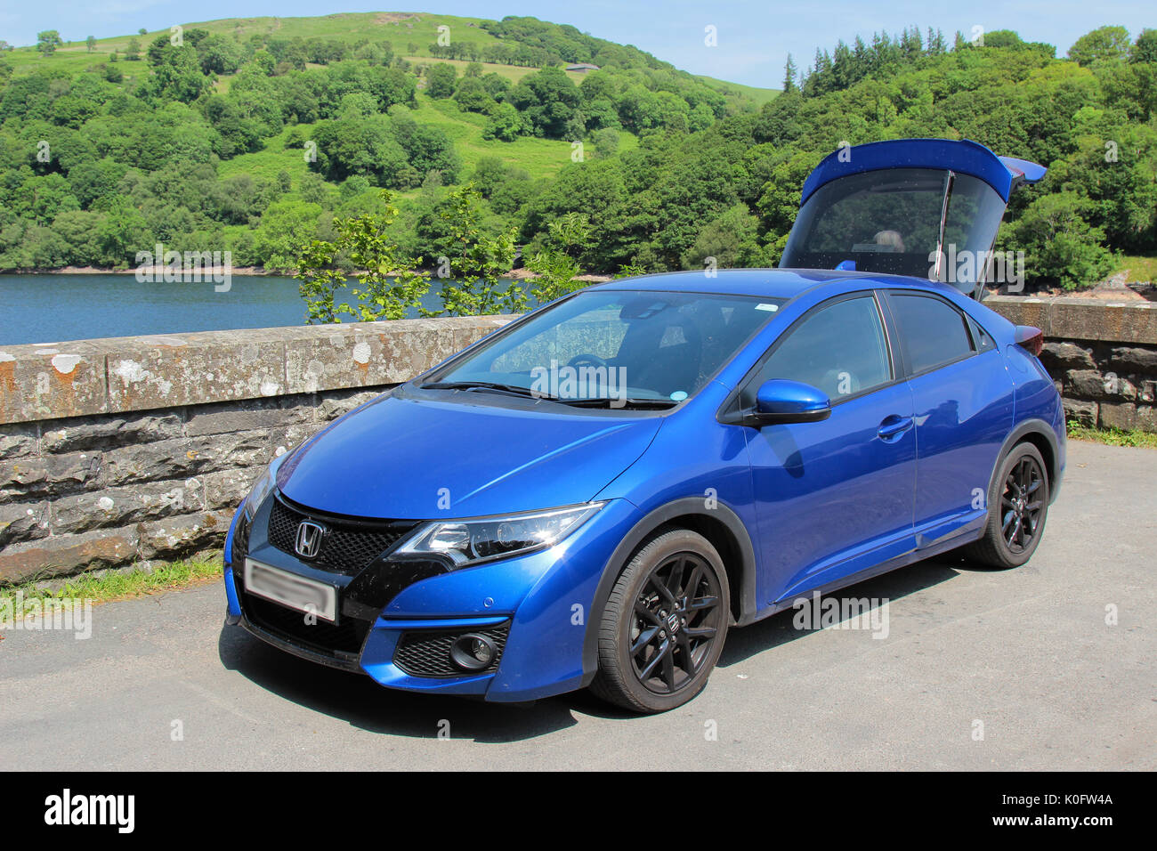 Blau 2016 Honda Civic mit Elan Valley Reservoir und Anzeigen im Hintergrund Stockfoto