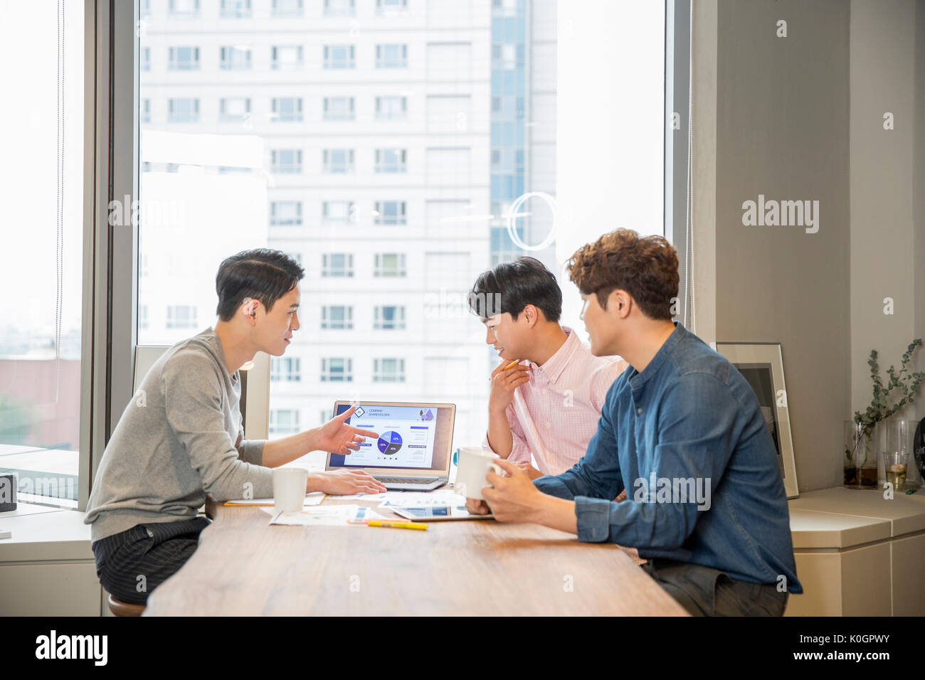Drei Unternehmer in einer Sitzung die gemeinsame Nutzung von Daten auf Notebooks Stockfoto