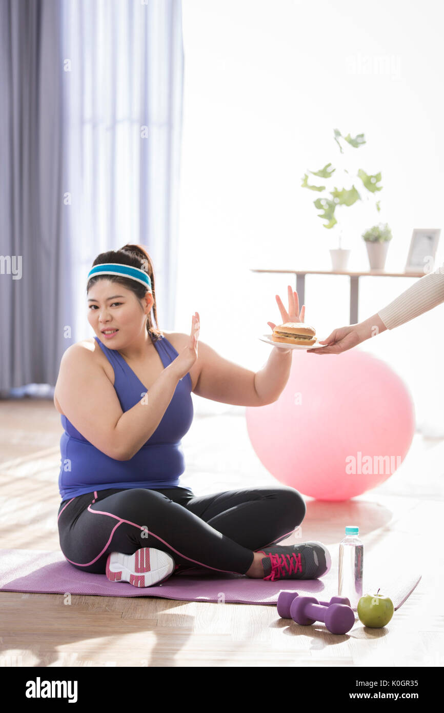 Junge fette Frau auf einer Diät hasst Hamburger Stockfoto