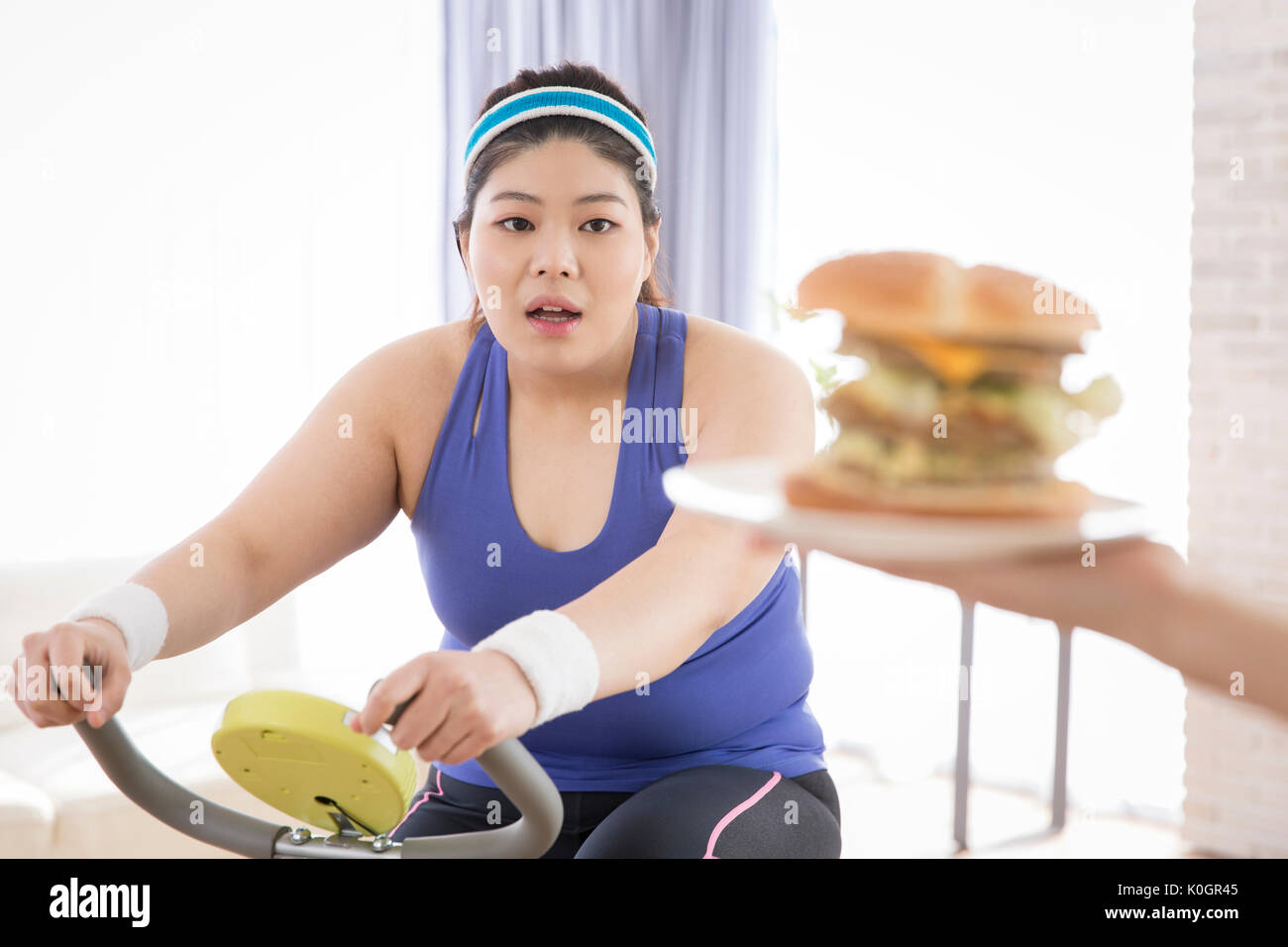 Junge fette Frau versucht schnell zu Essen - Essen während der Übung Stockfoto