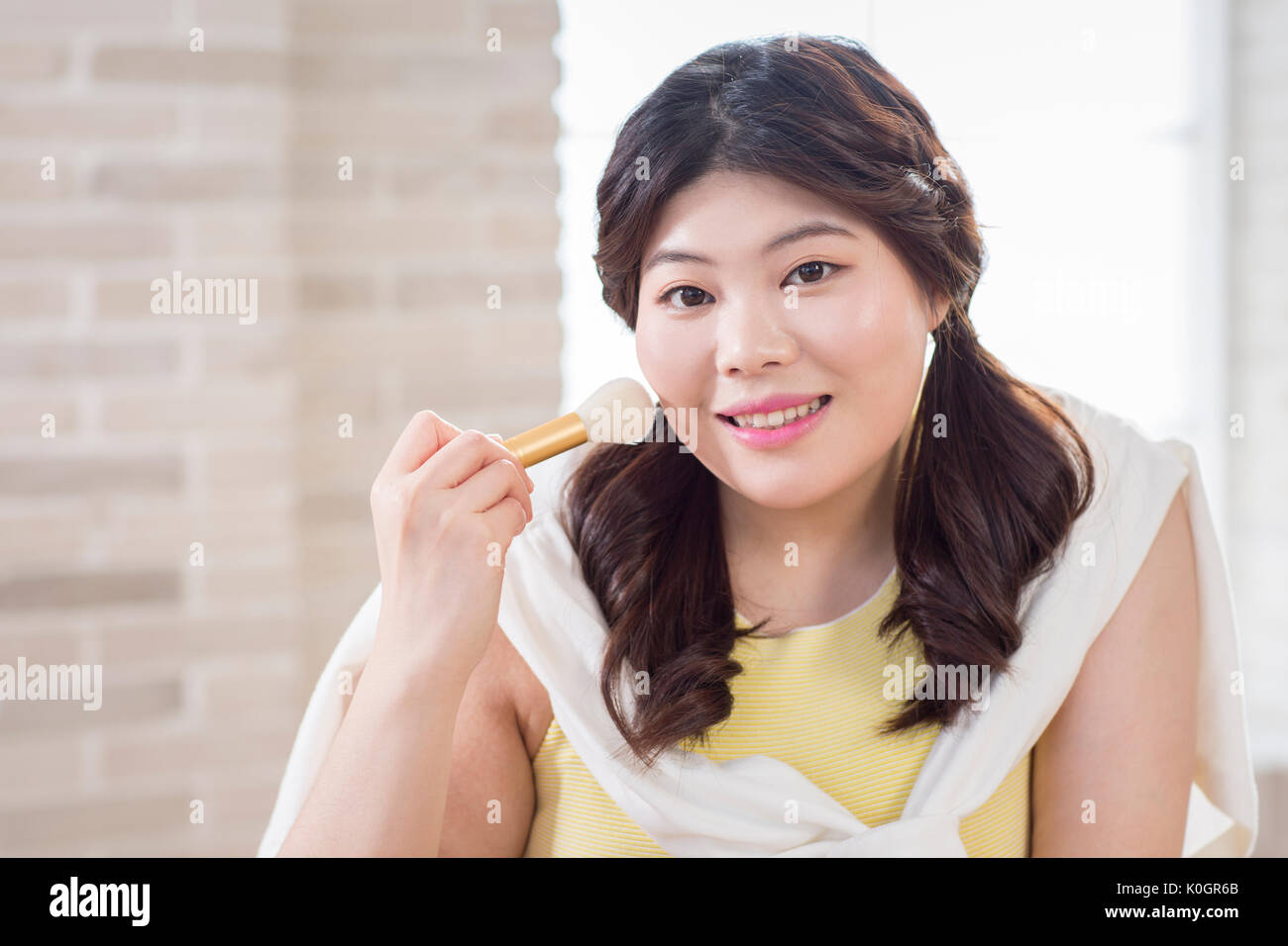 Portrait der junge lächelnde fette Frau auf Make-up Stockfoto