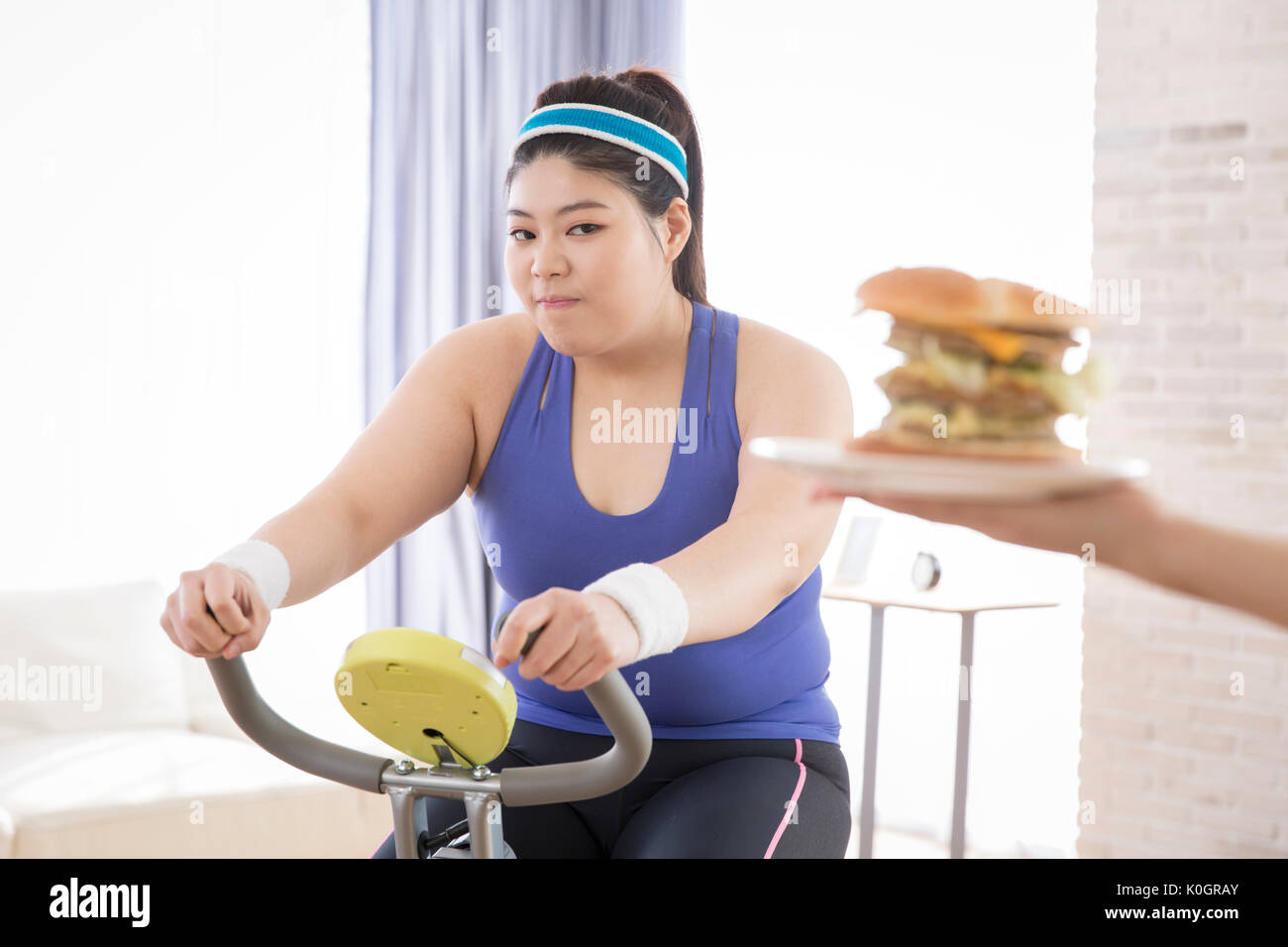 Junge fette Frau Ausübung versucht schnell zu Essen - Essen Stockfoto