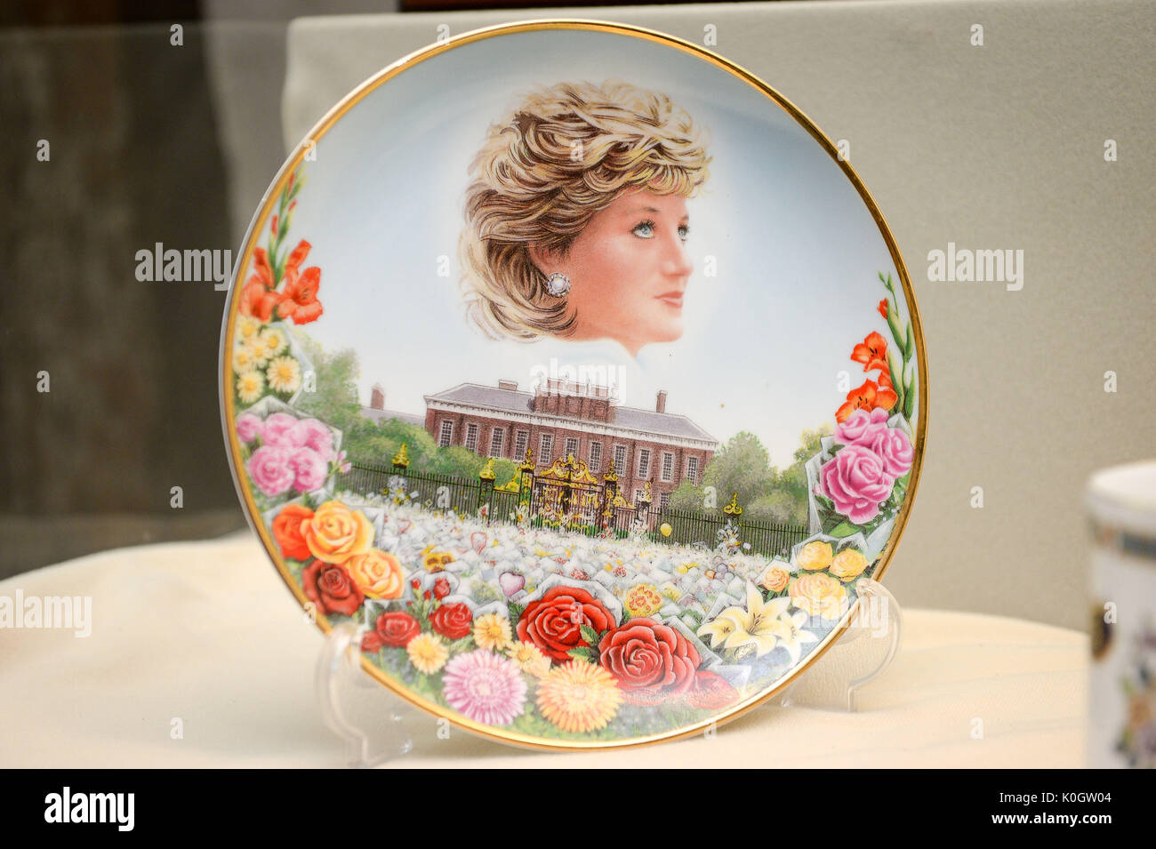 Eine Platte, die das Meer von Blumen auf den Kensington Palace und das Porträt von Diana, Prinzessin von Wales an der Gloucester Life Museum, wo eine Ausstellung von Diana Erinnerungsstücke ist auf Anzeige der Meilenstein 20. Jahrestag des Todes der Prinzessin zu markieren. Stockfoto