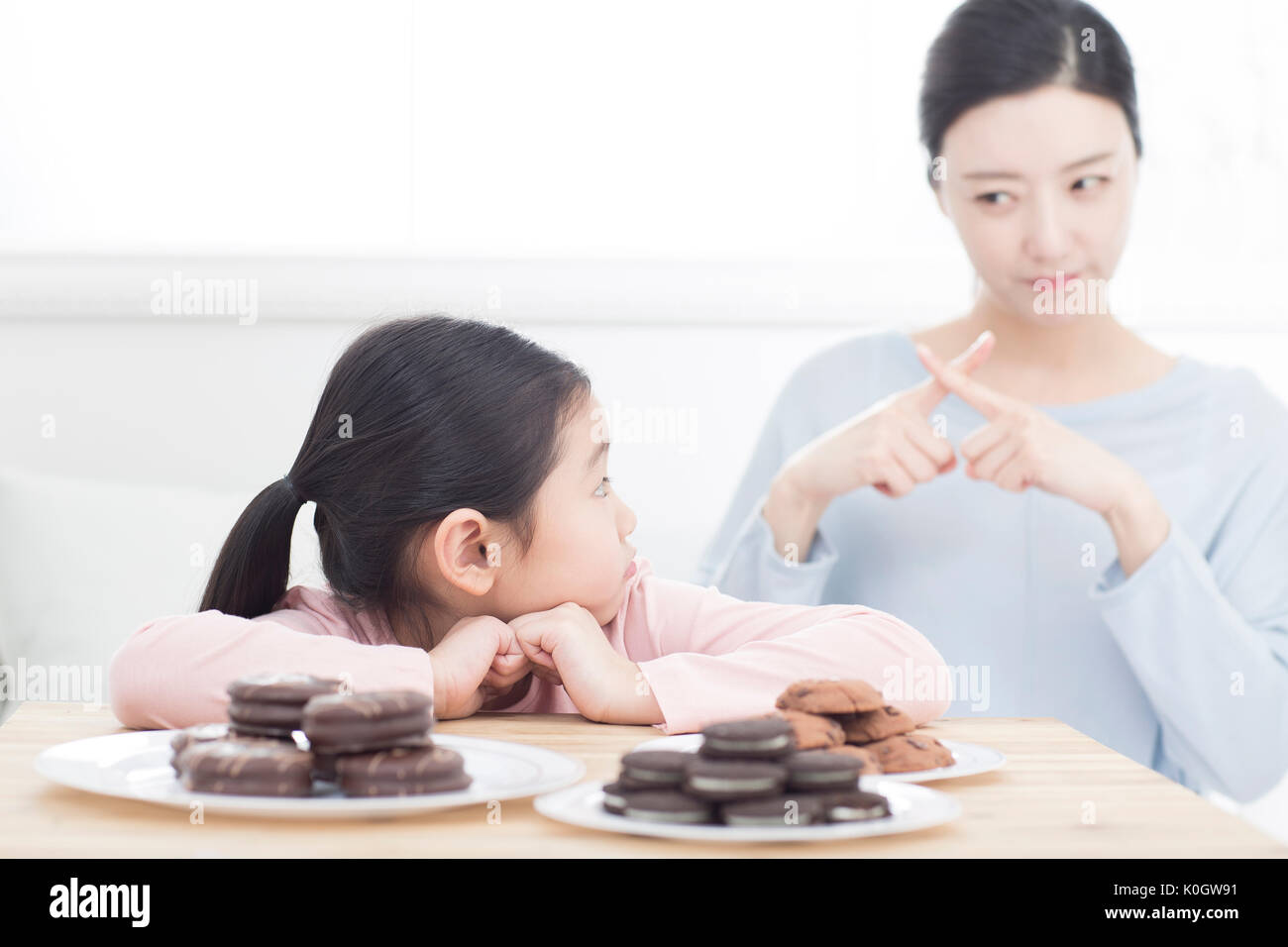 Die Mutter, die ihre Tochter nicht zu Süßigkeiten essen Stockfoto