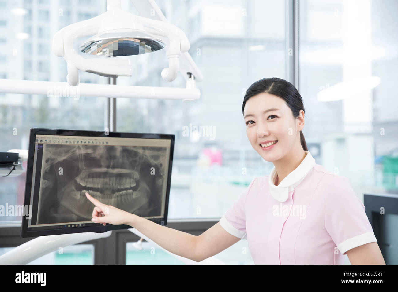 Portrait von lächelnden Dentalhygienikerin zeigen auf x-ray Bild Stockfoto