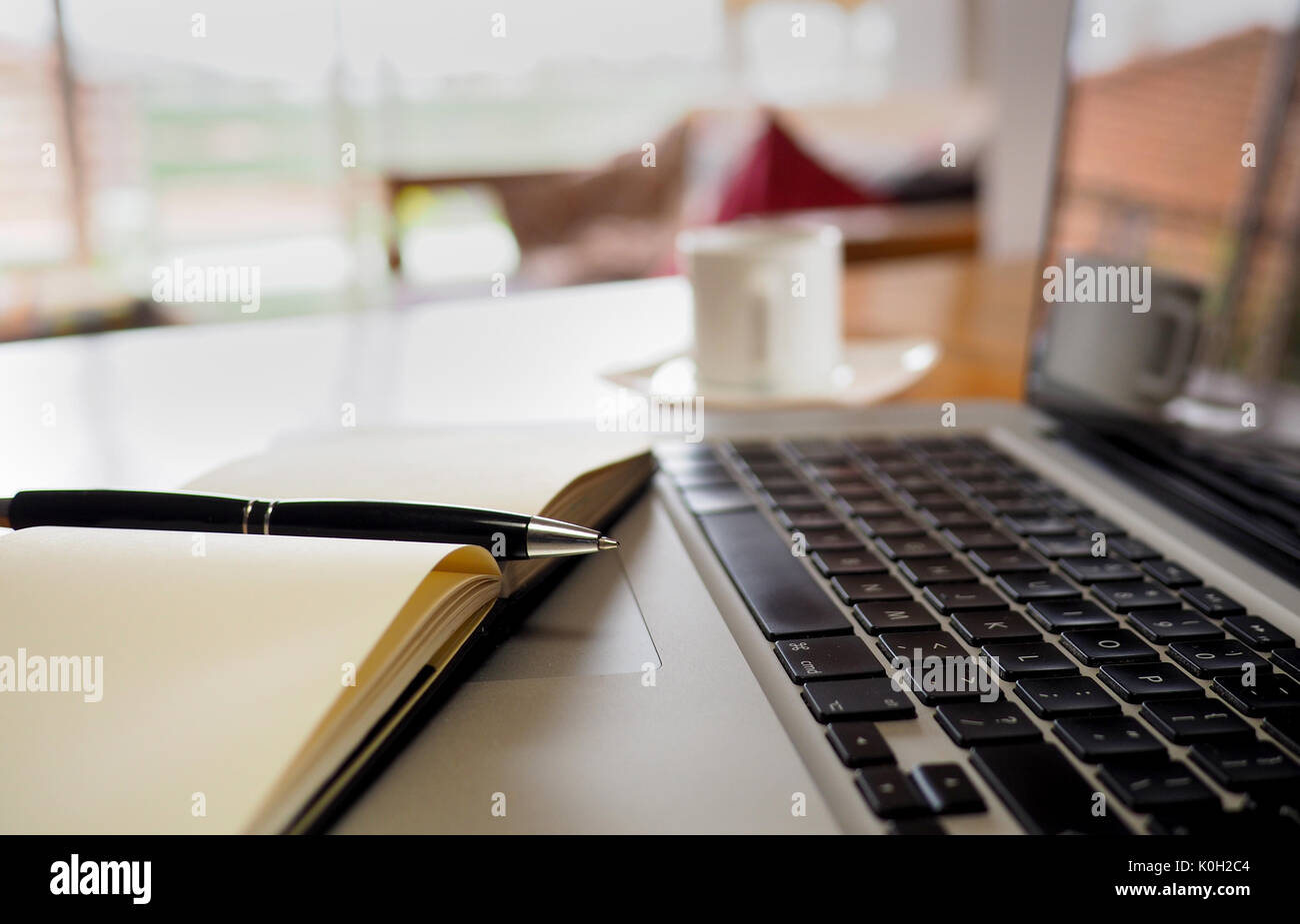 Notepad und Tastatur im Home Office, mit Kaffee Tasse Stockfoto
