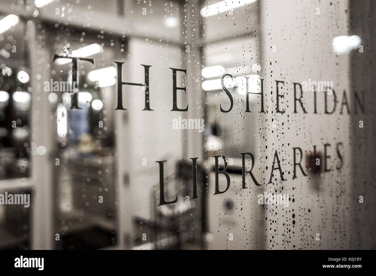 Ein Schild mit der Aufschrift "Die Sheridan Bibliotheken" in Regentropfen, 2016 abgedeckt. Mit freundlicher Genehmigung von Eric Chen. Stockfoto