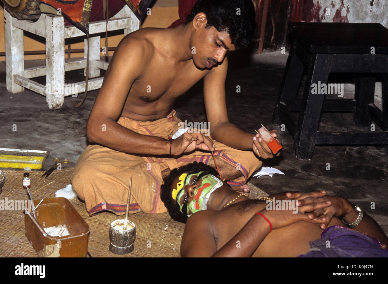 Assistant Anwendung stage Make-up zu Kathakali Performer, Cochin, Kerala, Indien Stockfoto
